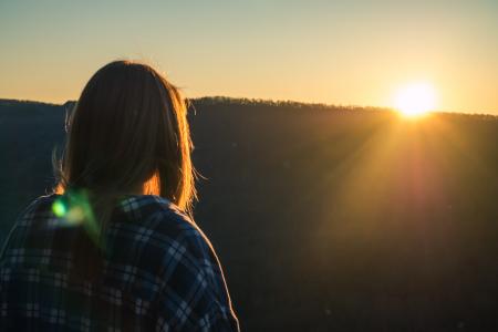 Woman Wearing Plaid Shirt Facing Sun during Golden Hour