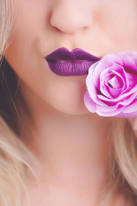 Woman Wearing Purple Lipstick With Pink Rose on Her Cheeks