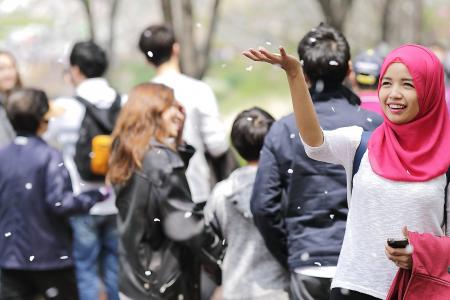 Woman Wearing Red Hijab Behind Person Wearing Black Jacket