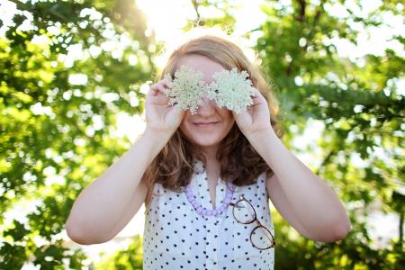 Woman Wearing White and Black Dotted Sleeveless Top Holding White Flower