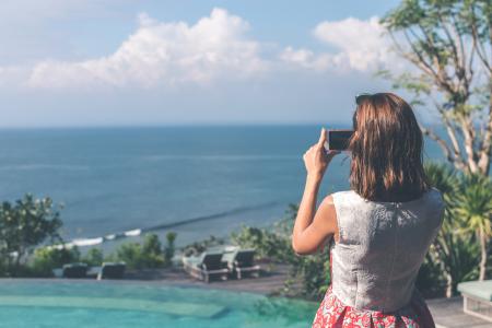 Woman Wearing White and Red Sleeveless Dress Taking Photo of Beach