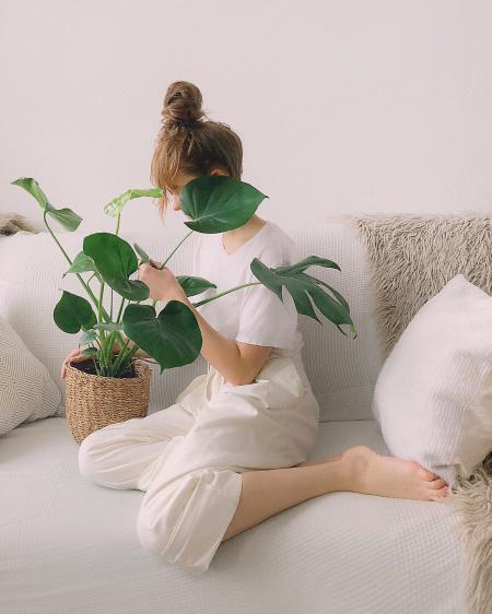 Woman Wearing White Crew-neck Shirt and White Pants While Sitting on White Couch