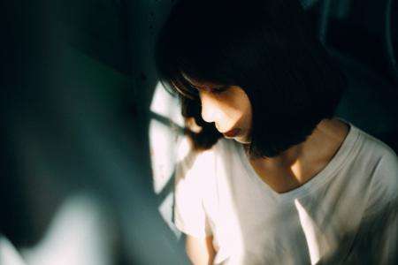 Woman Wearing White V Neck T Shirt Leaning on White Wall