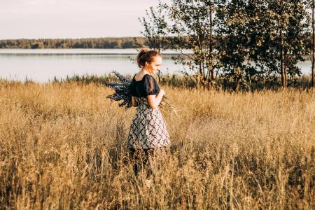 Woman Wears Black and Grey Dress Stands in Field