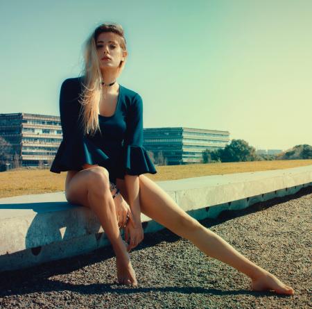 Woman Wears Black Scoop-neck Long-sleeved Blouse Seats on Grey Concrete Pavement