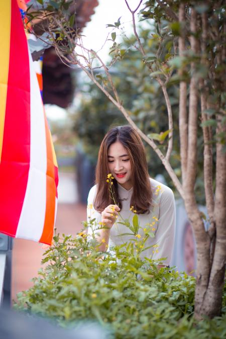 Woman Wears White 3/4 Sleeved Dress Holds Flowers