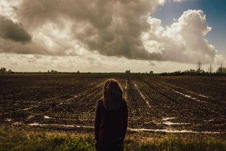 Women's Red Sweat Shirt Standing in the Middle of the Field