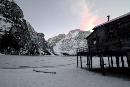 Wooden House Near Mountain Covered With Snow