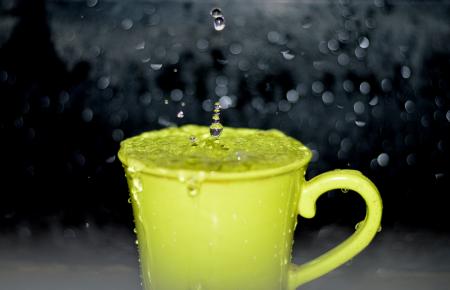 Yellow Ceramic Mug With Water Droplets in Time Lapse Photography