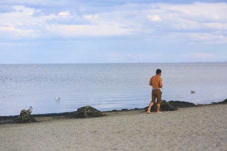 Young man walking on sand beach