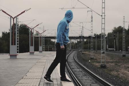 Young Man With Arms Outstretched Against Sky in City