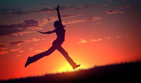 Young Woman Jumps at Sunset