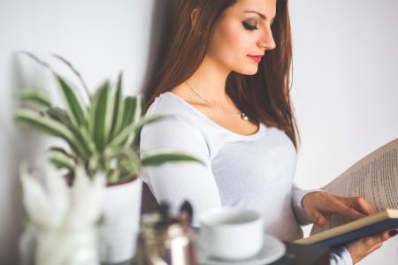 Young woman relaxing at home and reading a book