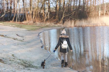 Young woman walking with her dog on the beach