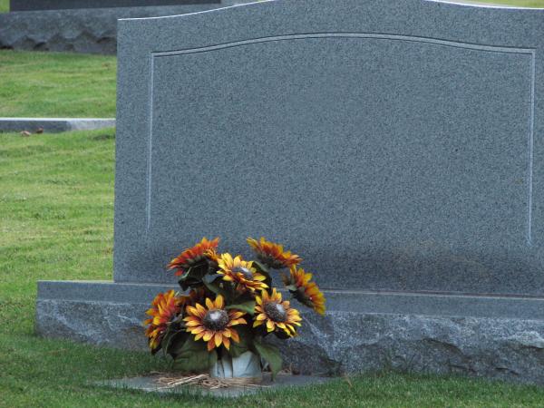 A blank tombstone with flowers