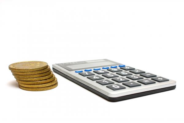 A calculator and a stack of gold coins