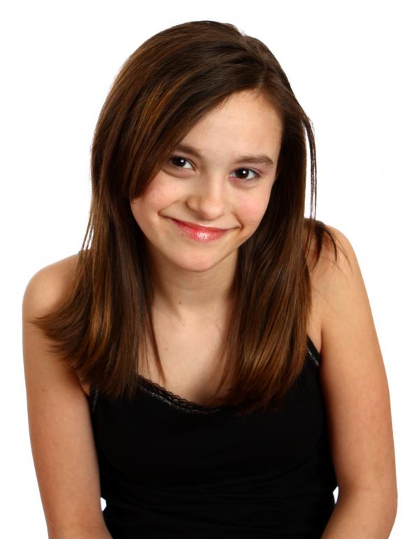 A cute young girl posing on white