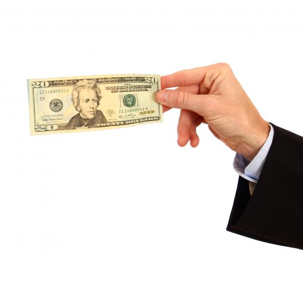A hand holding a twenty dollar bill