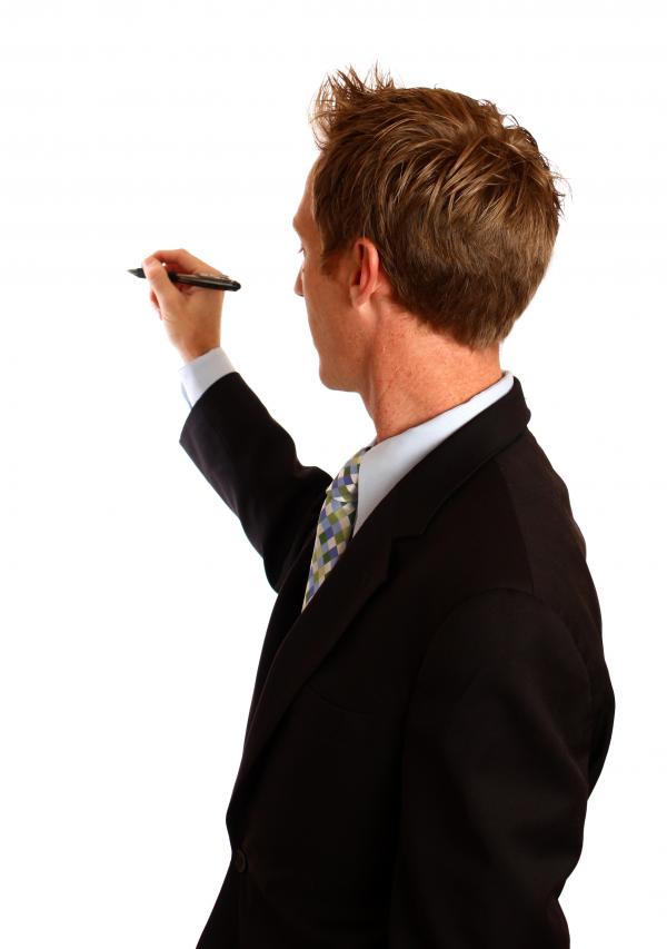 A young businessman writing with a pen