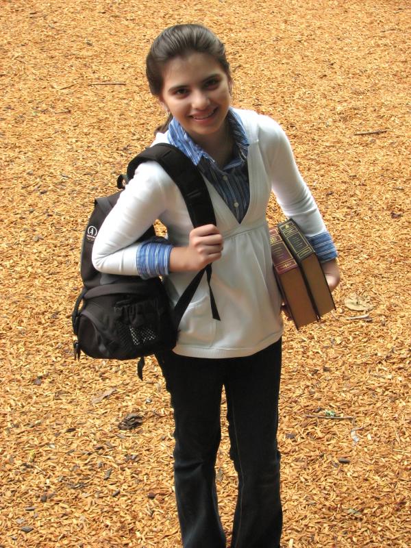 A young schoolgirl carrying books