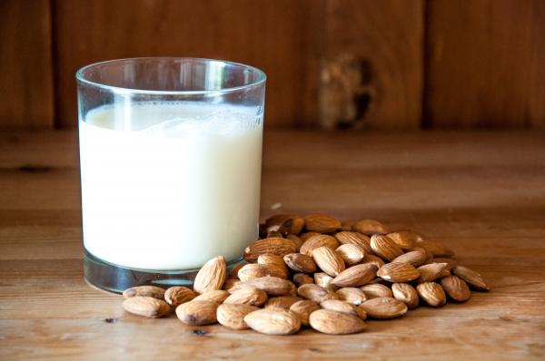 Almond milk with almonds on wood