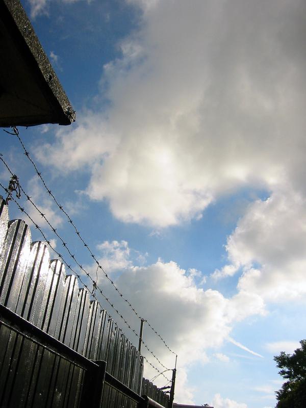 Barb wire fence against a cloudy sky