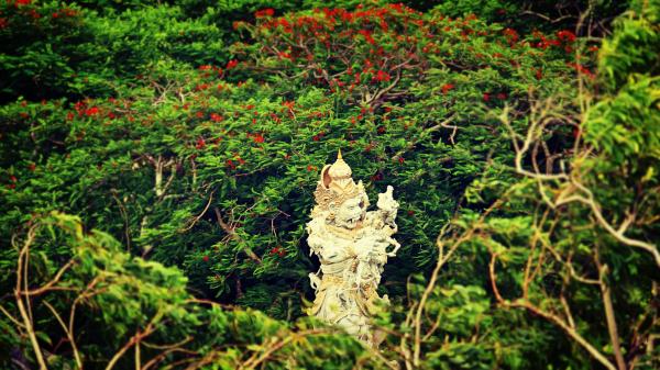 Beige Hindu Statue Surrounded by Trees at Daytime