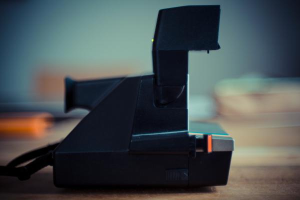 Black and Gray Instant Camera on Brown Wooden Table