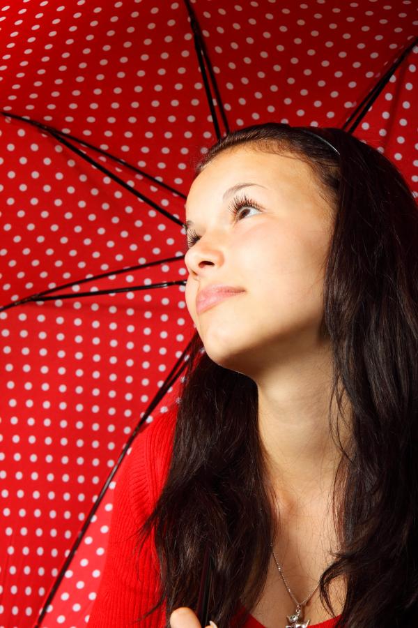 Black Haired Woman in Red Sweater Wearing Silver Dog Pendant Necklace Holding Black Red White Polka Dotted Umbrella