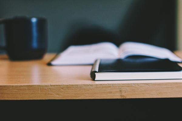 Black Notebook and Mug on Wooden Table