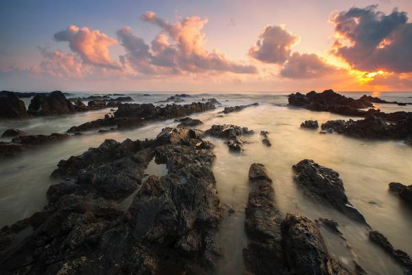 Black Rocks Surrounded by Body of Water during Daytime