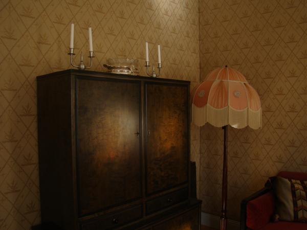 Black Wooden Wardrobe and White and Pink Pedestal Lamp Inside the Room