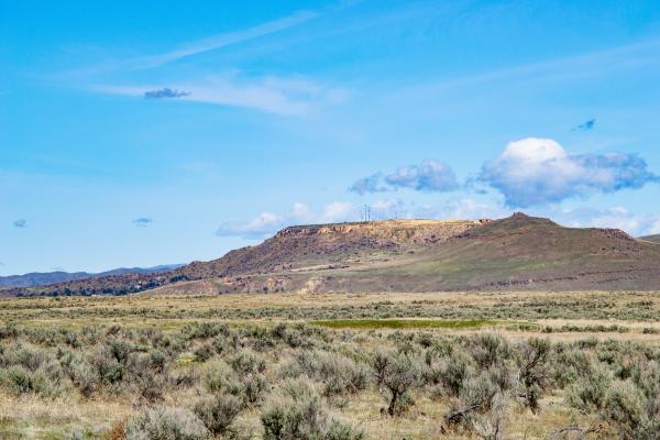Bright panoramic photo of the blue sky, high mountains and field