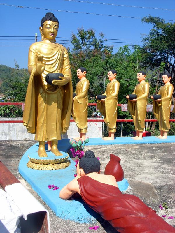 Buddha and followers receiving offering from a devotee