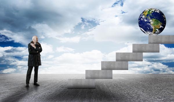 Businessman facing stairs with Earth globe
