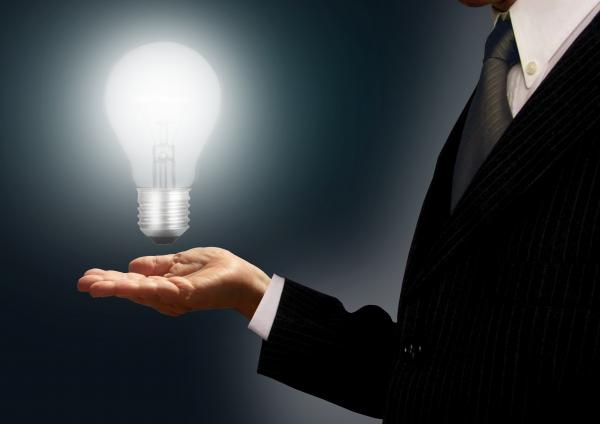 Businessman holding a lightbulb - Ideas and creativity concept