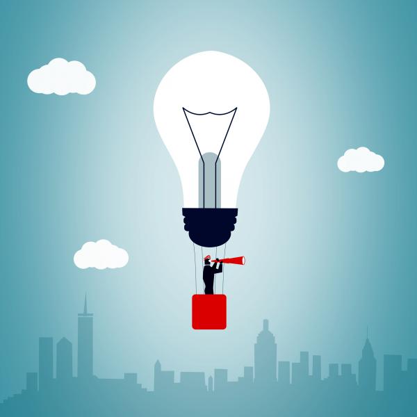 Businessman riding hot air balloon and scanning horizon