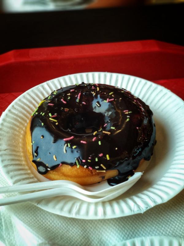 Chocolate Donut Above Round Paper Plate and Plastic Spoon and Fork