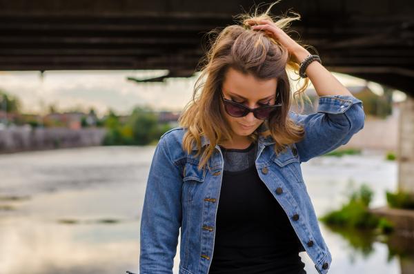 Close Up Photo of Woman Wearing Black Top and Blue Denim Button-up Jacket