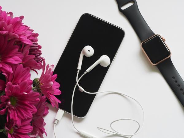 Close-Up Photography of Earphones on Top of Iphone 6 Near Flowers