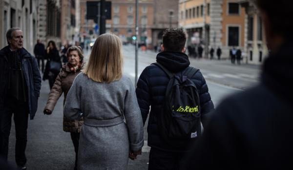 Couple Holding Hands While Walking on the Street