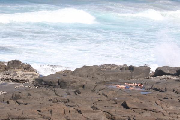 Couple laying on the rocky beach