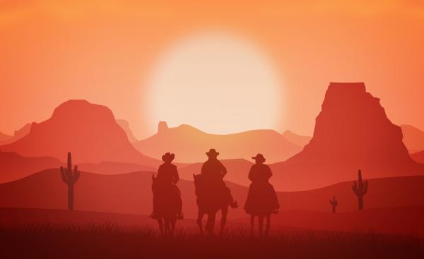 Cowboys riding horses at sunset