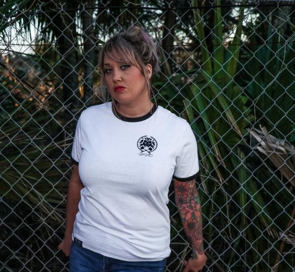 Female Wearing Black and White Crew-neck T-shirt and Blue Denim Bottoms Leaning on Chicken Wire
