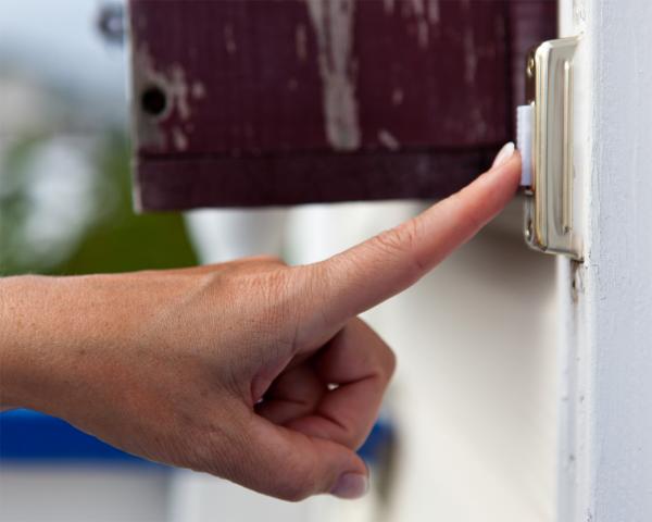 Finger pressing a doorbell