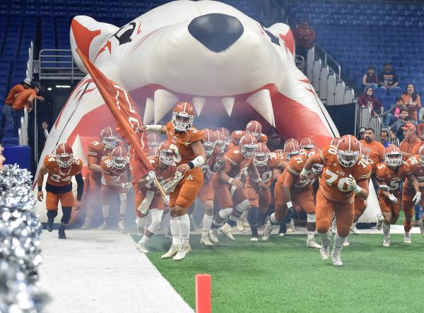 Football Team Running Thru Football Field