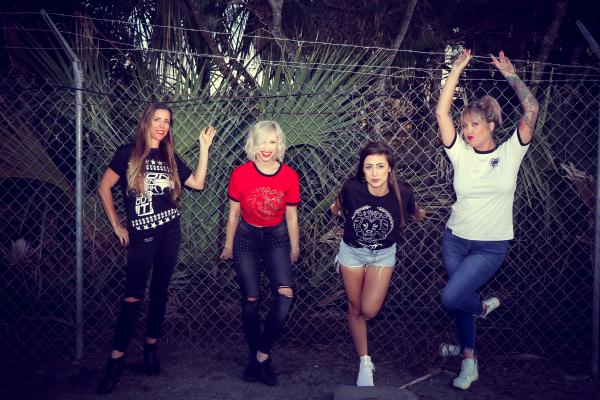 Four Woman Leaning on Chain Link Fence