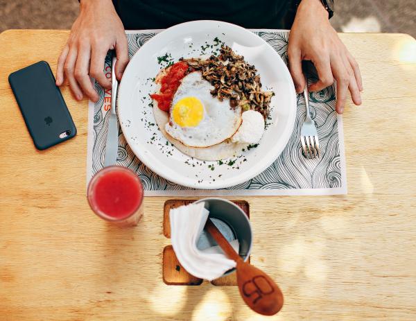 Fried Egg With Plain Rice on White Plate Beside Stainless Steel Fork With Clear Drinking Glass on Top Table