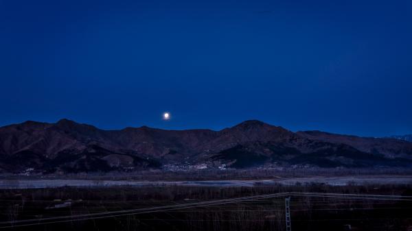 Full Moon Above the Mountain Ranges Near Town