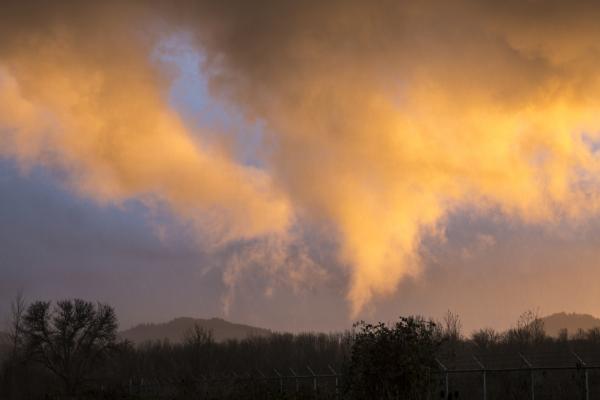 Gold sunset reflection on drifting clouds, Oregon